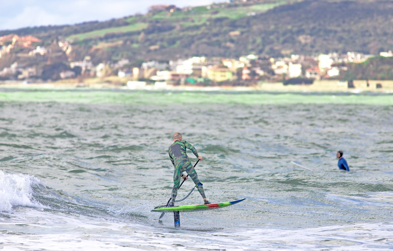 Pratiquant de stand-up paddle sur une planche à foil