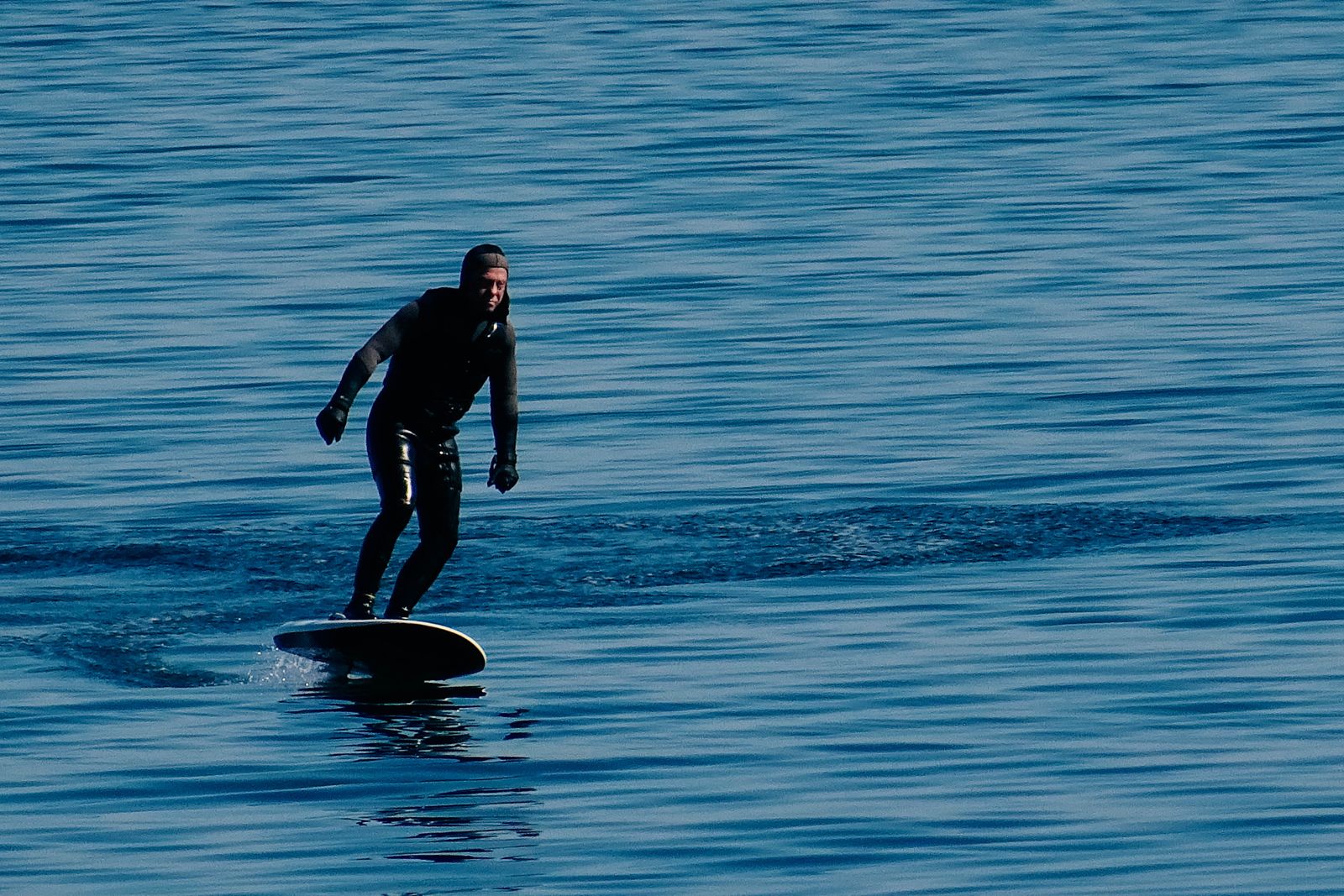 Rider en eFoil au-dessus d’un lac calme