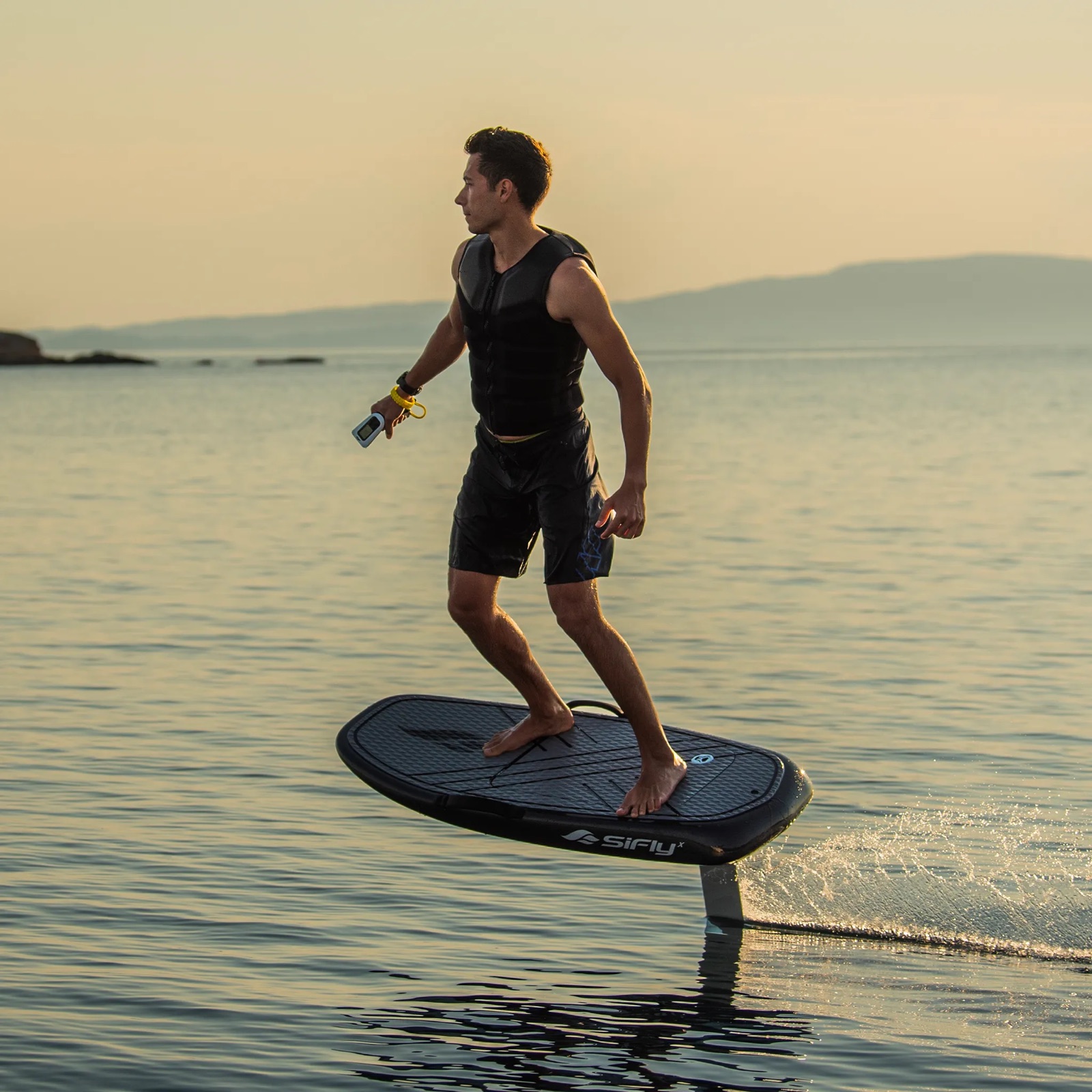 Rider SiFly glissant sur une eau calme dans la lumière dorée du soir