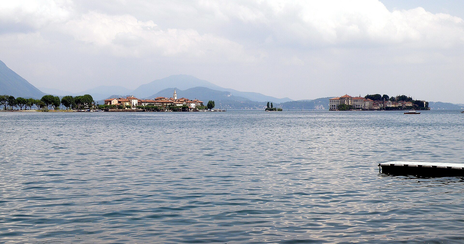 L’Isola dei Pescatori a sinistra e l’Isola Bella a destra sul lago Maggiore, viste dalla riva con un pontile galleggiante in primo piano